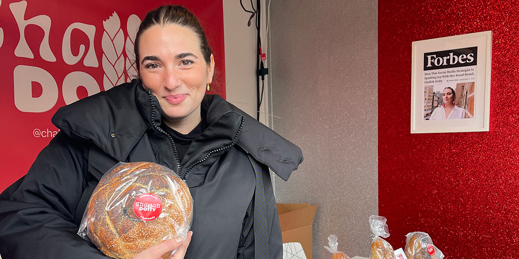Dolly Meckler poses with her challah bread in a store.